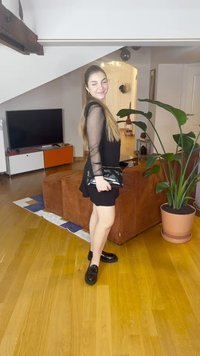 Fekete mini ruha áttetsző hosszú ujjakkal, fekete kézitáska és fekete mokaszin. Sima textúrájú és minimalista kialakítású.