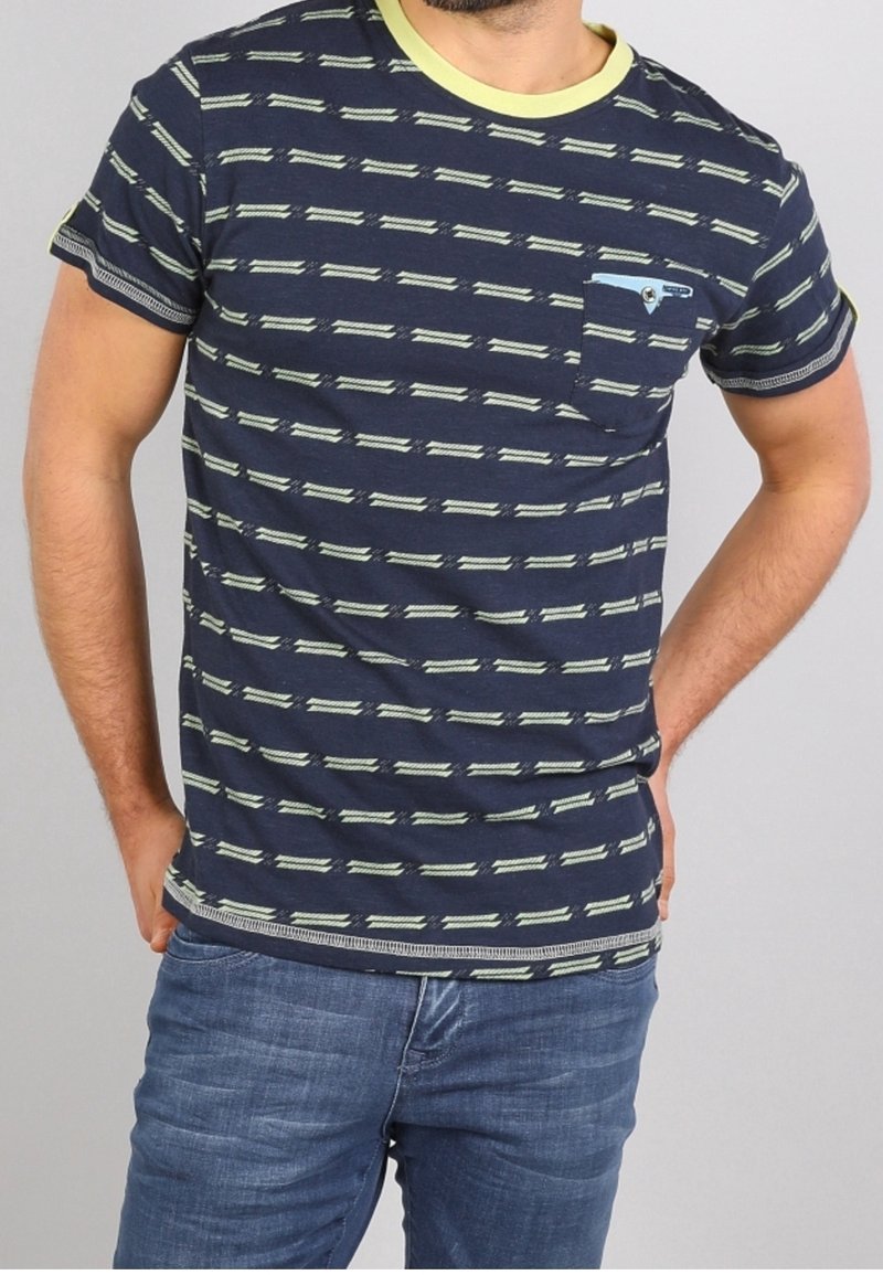 T-paita tummansinisestä puuvillasta, jossa on vaaleanvihreitä vaakaraitoja, ribattu pyöreä kaula-aukko, lyhyet hihat ja tasku, jossa on sininen yksityiskohta.