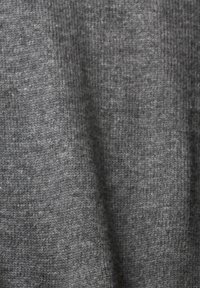 Gros plan d’un tissu gris doux tricoté avec une texture côtelée fine et de subtiles variations de couleur.