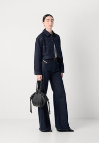 Mørk denim cropped jakke med knappelukking, kombinert med brede mørke jeans. Inkluderer en svart håndveske med teksturerte detaljer.