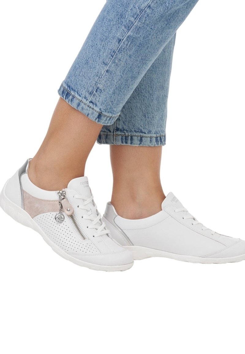 Baskets blanches en cuir lisse et perforé, accentuées de suède gris clair et beige, avec un détail de fermeture éclair sur le côté.
