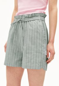 Grün gestreifte Shorts aus leichtem Stoff, mit elastischem Taillenbund und Kordelzug, Seitentaschen und genähtem Saum.