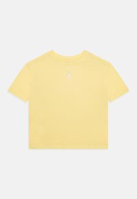 Žluté bavlněné tričko s kulatým výstřihem a krátkými rukávy. Obsahuje malé bílé logo Jordan umístěné na středu hrudi.