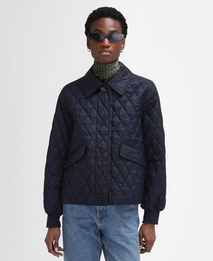 Veste matelassée marine avec fermeture à boutons et deux poches avant. Elle présente un col et des poignets côtelés, accompagnée d'une écharpe à pois.