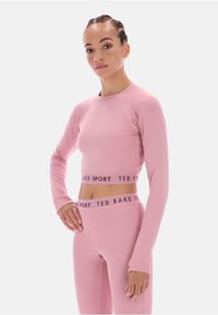 Rózsaszín sportos hosszú ujjú felső és magas derekú leggings "TED BAKER SPORT" logóval. Sima tapintású, testhezálló dizájn és rugalmas anyag.