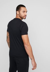New Balance ESSENTIALS STACKED LOGO  - Camiseta estampada - black