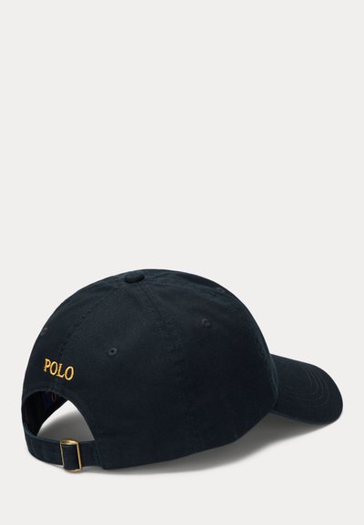 Schwarze verstellbare Baseballkappe mit goldener „POLO“-Stickerei auf der Rückseite und einem Metallverschluss am Riemen, gezeigt aus einer seitlichen Ansicht von hinten.