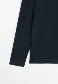 Koszula z długim rękawem w ciemnym granatowym kolorze, wykonana z bawełny; cechuje się gładką teksturą, prostym dołem i starannie wykończonymi mankietami.