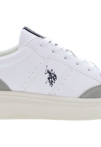 Vit lädersneaker med grå mocka detaljer, rund tå, snörningsdesign, perforerade detaljer och en svart polo-spelare logotyp på sidan.