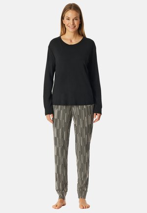 Svart långärmad topp kombinerad med svartvita randiga pyjamasbyxor. Mjuk kvalitet, avslappnad passform och elastiska mudd vid byxorna.