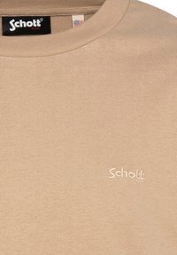 Beige Sweatshirt mit rundem Ausschnitt, gerippter Textur und kleinem gesticktem "Schott"-Logo auf der Brust. Hergestellt aus weichem Stoff.
