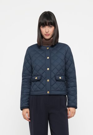 Navy quilted jacket with gold snap buttons, round neckline, and two front pockets. Features a textured fabric and cropped design.