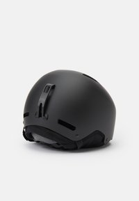 Černá helma s matným povrchem, kulatý tvar, nastavitelný popruh a ventilační otvory. Obsahuje klip a polstrovaný interiér pro pohodlí.