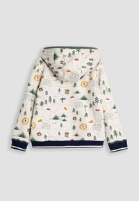 Gaiša bež džemperis ar kapuci ar kempinga tematikas printu. Iekļauj zaļus kokus, teltis, kartes un savvaļas dzīvnieku ilustrācijas. Garo izliekumu aproces un apakšmalu.