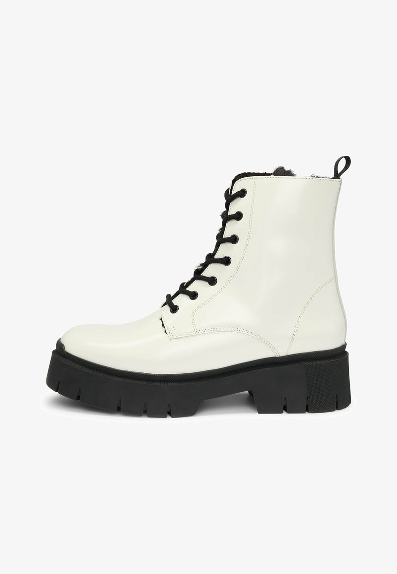 Witte, glanzende leren enkellaars met zwarte veters, contrasterende zwarte chunky zool en een bontvoering aan de bovenkant voor extra textuur en detail.