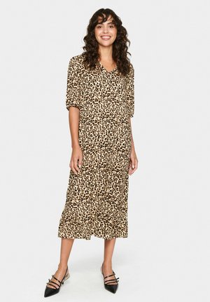 Leopardenmuster Midi-Kleid mit V-Ausschnitt und kurzen Ärmeln, aus leichtem Stoff gefertigt, mit lockerer Passform und gestuftem Rock. Schwarze Ballerinas.