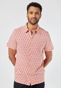 Korte mouwen shirt in het rood met een bloemenpatroon. Gemaakt van lichtgewicht stof met een button-down kraag en een rechte zoom.