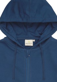 Felpa blu con zip, dotata di cappuccio con cordino, texture morbida e un'etichetta che riporta la scritta "greenjama" con taglia 38, fabbricata in Portogallo.