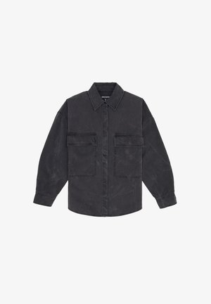 Black, oversized shirt with a button-up front, two chest pockets, and a classic collar. Made of textured fabric, featuring a relaxed fit.
