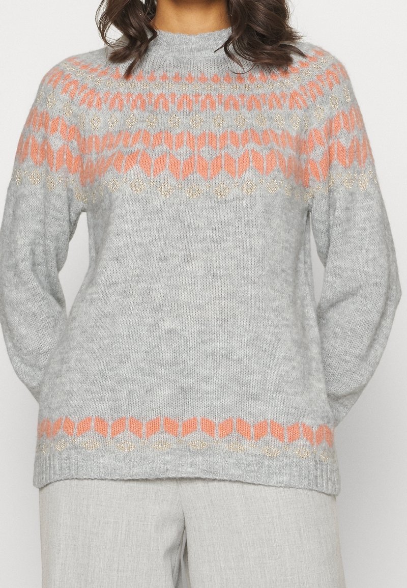 Jasnoszary sweter dzianinowy z okrągłym dekoltem, zdobiony geometrycznym wzorem w kolorze pomarańczowym i złotym na piersi i rękawach.