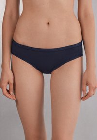 Donkerblauwe bikini slipjes van gladde stof, met een low-rise tailleband en een minimalistisch ontwerp met strakke randen.