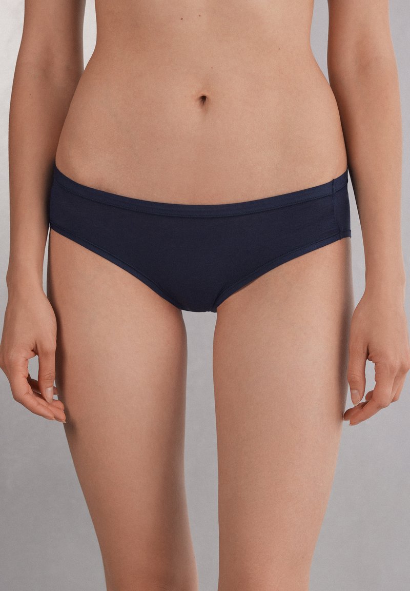 Donkerblauwe bikini slipjes van gladde stof, met een low-rise tailleband en een minimalistisch ontwerp met strakke randen.