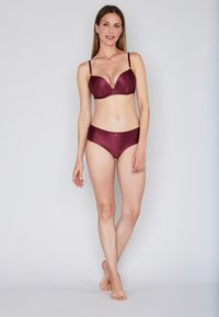 Dunkelrotes BH- und Slip-Set mit gerippter Textur, ausgestattet mit verstellbaren Trägern und dezenten Details am Taillenbund.