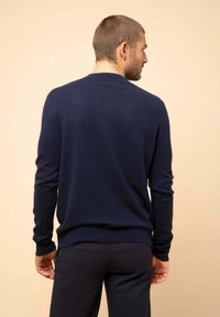 Suéter de mezcla de lana azul marino con mangas largas, cuello redondo y dobladillo acanalado. Textura suave, diseño ajustado, sin patrones o acentos visibles.
