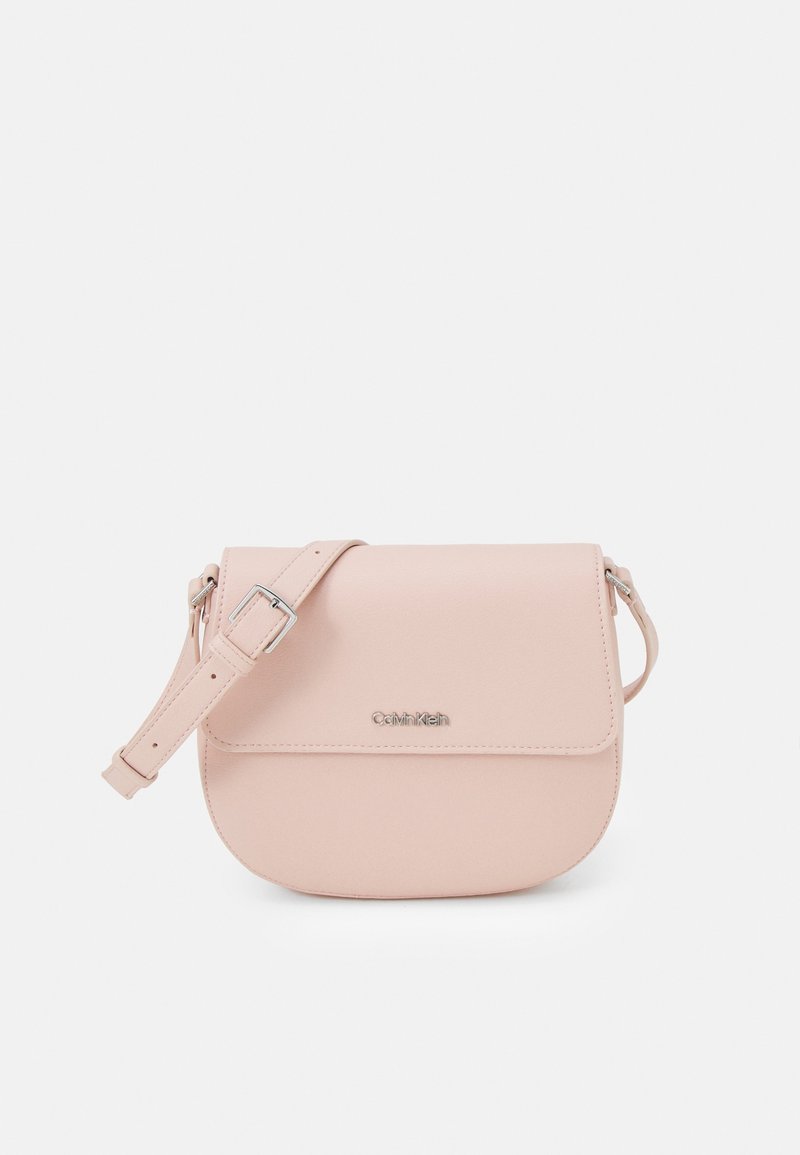 Borsa crossbody in finta pelle rosa chiaro con chiusura a patta, una sola tracolla regolabile e un dettaglio logo argentato. Design con fondo arrotondato.