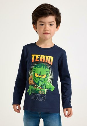 Langærmet navy T-shirt med en grøn ninja grafik med "TEAM" ovenfor og "NINJA" nedenfor, lavet af blødt bomuldsstof.