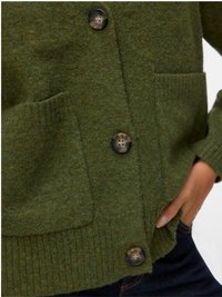 Cardigan verde em lã com bainha canelada, dois bolsos frontais e quatro botões grandes com padrão. Tecido texturizado com acabamento suave.