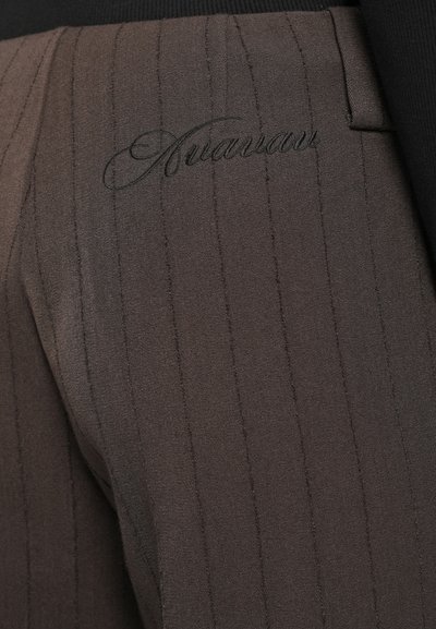 Brązowe spodnie w prążki wykonane z gładkiego materiału, z haftowanym logo. Projekt zawiera dopasowany krój i subtelny połysk.