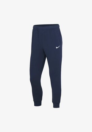 Granatowe spodnie dresowe Nike z elastyczną talią, bocznymi kieszeniami, ściągaczami przy kostkach i białym logo Nike Swoosh na lewej udzie.