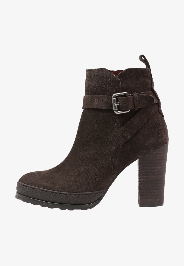 Bottine en daim marron foncé avec talon bloc, détail de bride à boucle et languette à l'arrière.