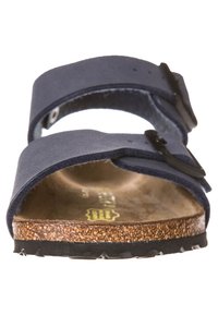 Sandalo blu navy con tomaia in camoscio, soletta in sughero e fibbia nera regolabile. Suola in gomma testurizzata per una buona aderenza.