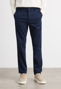 Navy blue trousers made of soft fabric, featuring a straight leg design, two side pockets, and a button closure at the waist.