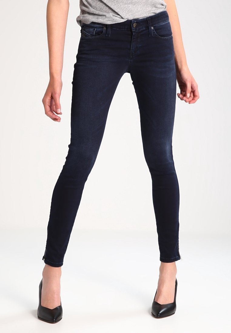 Skinny navy blue jeans made of denim, featuring a classic five-pocket design, mid-rise waist, and subtle fading on the thighs and knees.