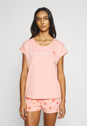 Roze katoenen T-shirt met korte mouwen, met de tekst "Maak vandaag geweldig". Gecombineerd met bijpassende shorts bedekt met hartpatronen.