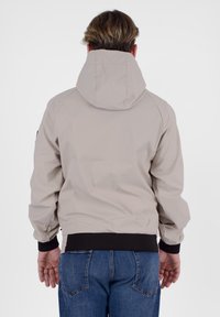 Giacca con cappuccio beige in tessuto sintetico liscio. Presenta un orlo e polsini a coste neri, mostrata da dietro.