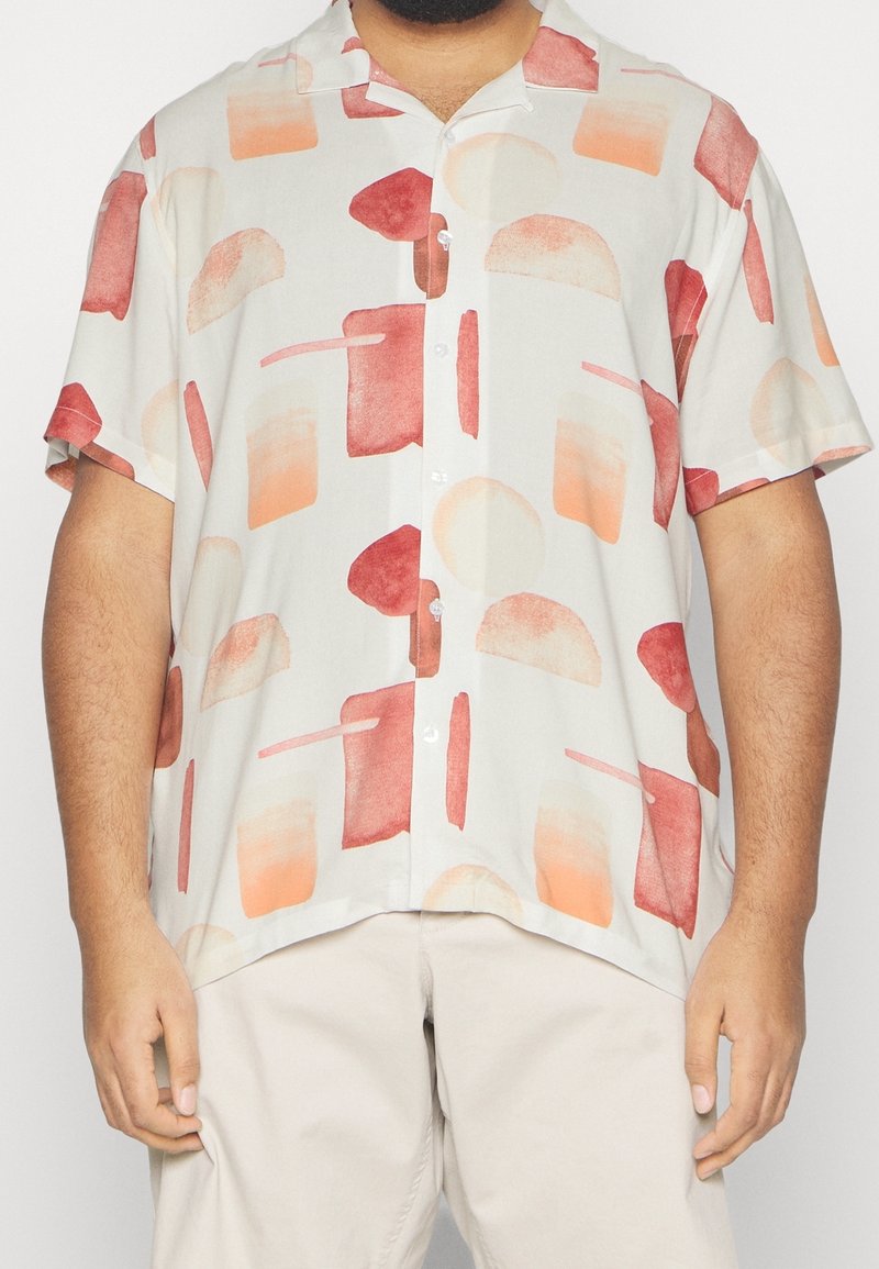 Camicia a maniche corte con bottoni in tessuto leggero, caratterizzata da motivi astratti in tonalità di rosso e arancione su uno sfondo crema.