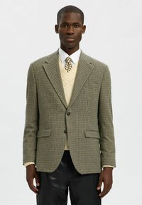 Marynarka w wzór houndstooth w stonowanych odcieniach zieleni i brązu, charakteryzująca się dopasowanym krojem, klapami w kształcie notcha oraz dwiema przednimi kieszeniami.