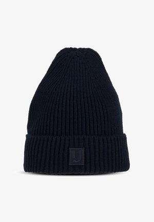 Sötét tengerészkék, kötött sapka bordás textúrával, kúpos koronával és hajtott szegéllyel. Elöl egy kis négyzet alakú folt látható logóval.