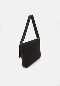 Borsa a spalla nera realizzata in tessuto, con una superficie liscia, forma rettangolare, tracolla regolabile e un design minimalista senza decorazioni.