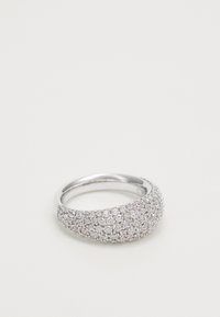 Bague en argent avec un large bandeau incrusté densément de petites pierres précieuses claires scintillantes sur un fond blanc uni.