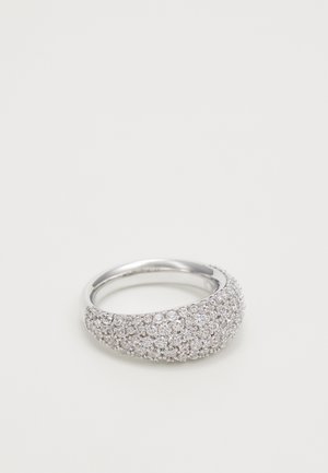 Srebrny pierścionek z szeroką obrączką, gęsto osadzony małymi, błyszczącymi, przezroczystymi kamieniami na jednolitym białym tle.