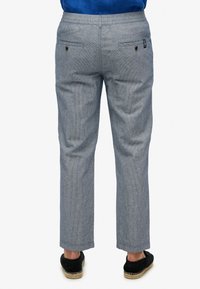 Lichtblauwe gestreepte broeken met een elastische tailleband, twee achterzakken en een rechtlijnig ontwerp, gecombineerd met zwarte instappers.