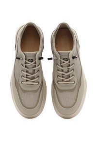 Zapatillas beige con parte superior de malla y acentos sintéticos, que presentan una puntera redondeada, diseño de cordones y detalles texturizados en los lados.