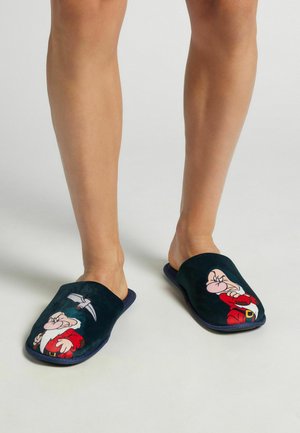 Marineblauwe fluwelen instapslippers met een geborduurd cartoonfiguurontwerp aan de voorkant. Zachte textuur; geen zichtbare hardware of accenten.