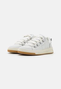 Weiße Leder-Sneaker mit abgerundetem Zehenbereich, dickem cremefarbenem Gummisohle, auffälligen Schnürsenkeln und subtiler Markenkennzeichnung auf der Zunge und den Seitenpaneelen.