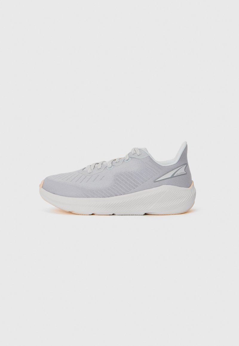 Light gray athletic shoes with a textured upper, cushioned white midsole, and subtle peach accents on the outsole. Lace-up design.